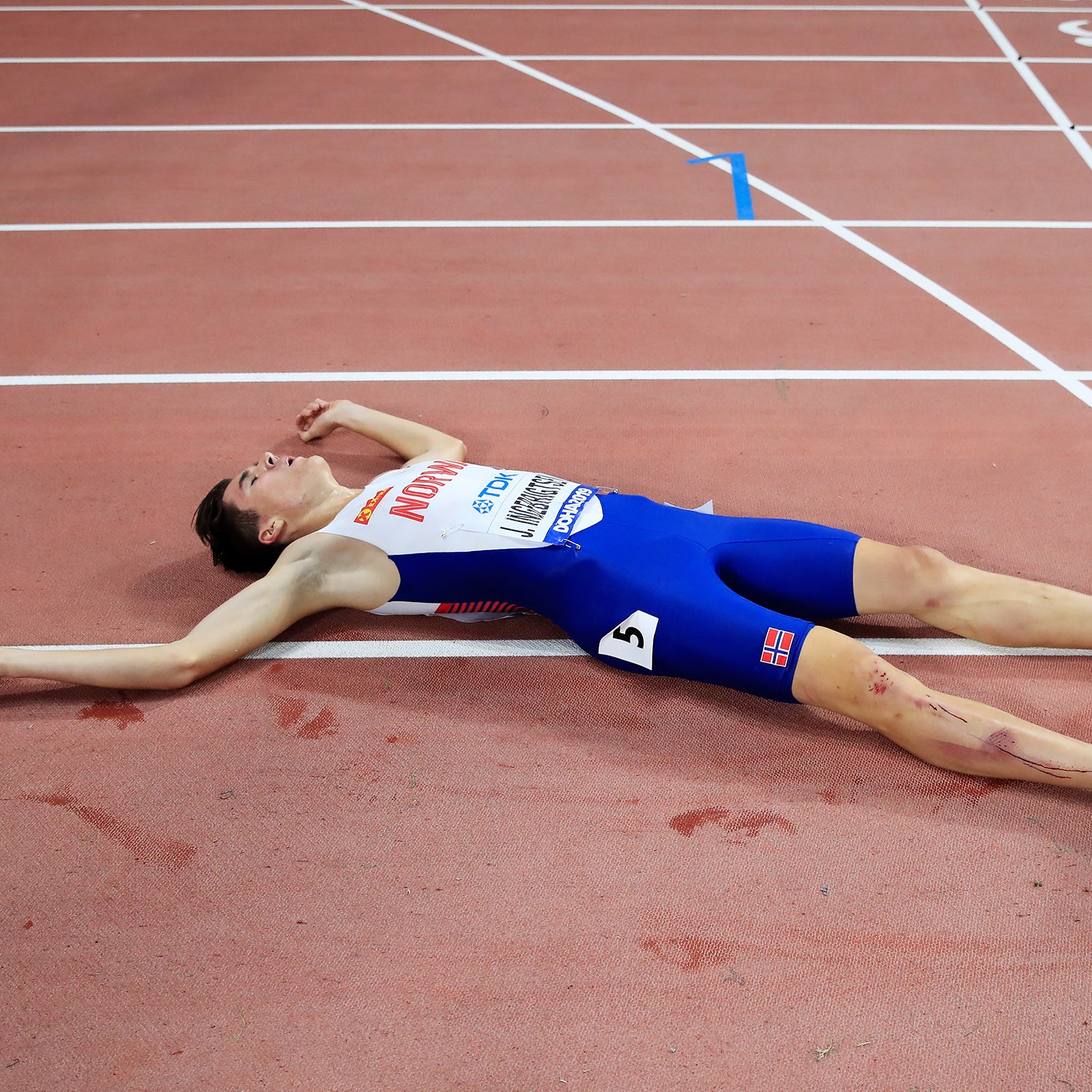 Jakob Ingebrigtsen of Norway lies on the track after crossing the finish line in the Men's 5000 metres final during day four of 17th IAAF World Athletics Championships