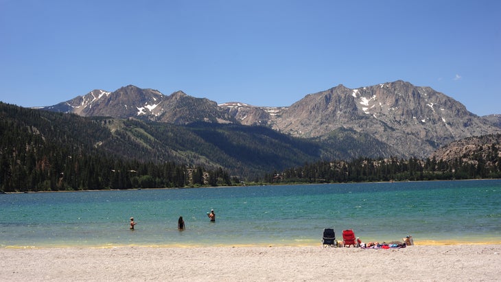 Beachgoers in June Lake with the Sierra Nevadas in distance.