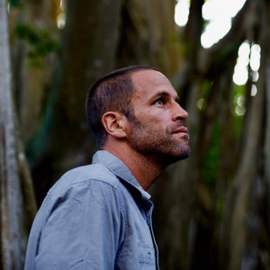 Jack Johnson looks upward in a nature background