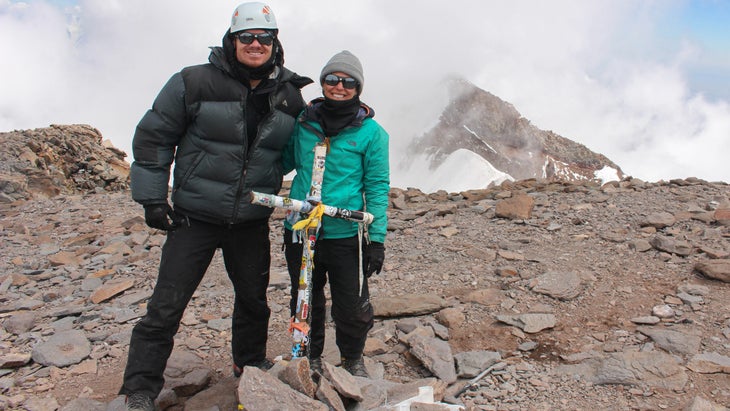 Two climbers stand atop Aconcagua.