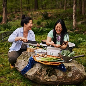 Sarah and Kaitlin Leung cooking outdoors