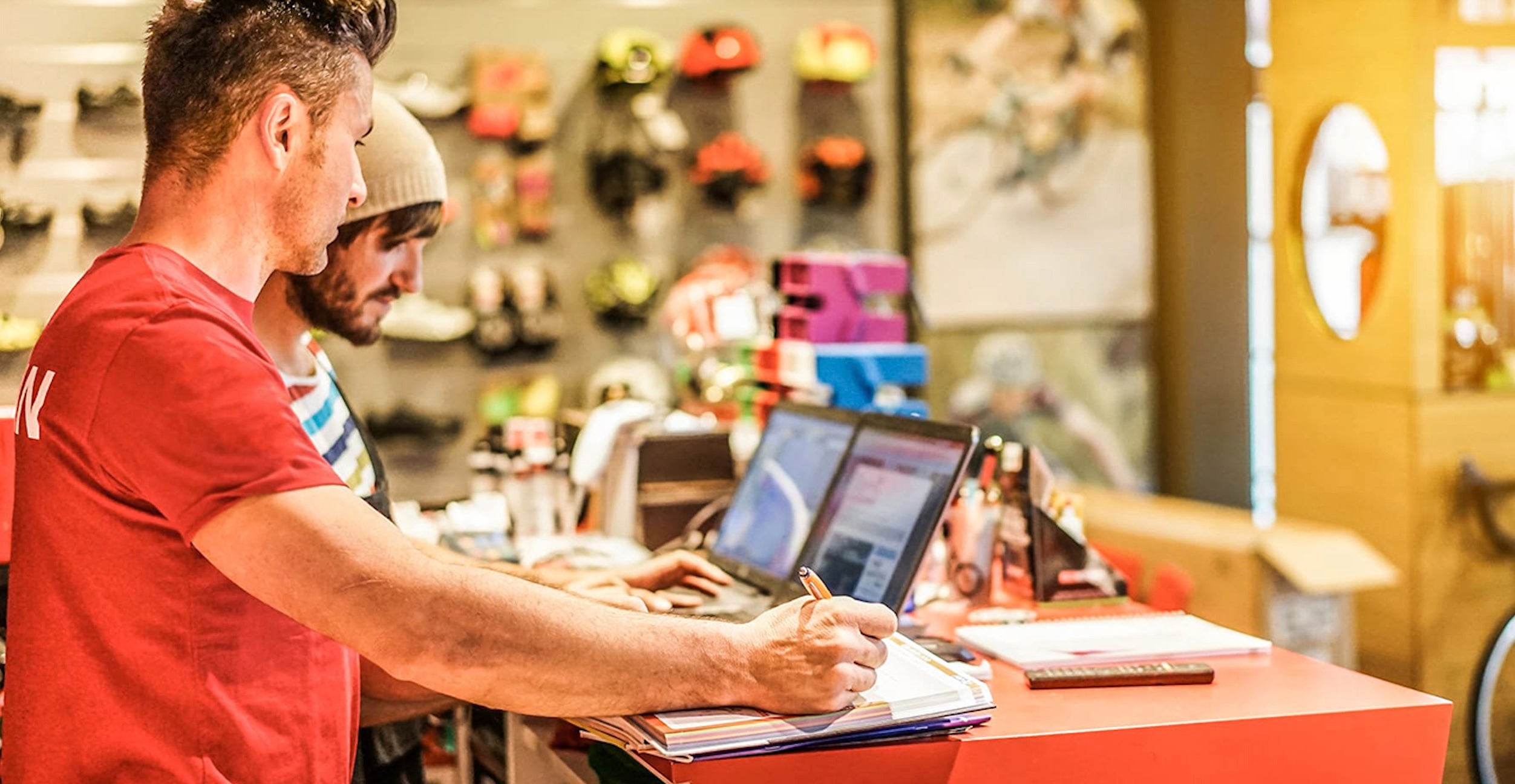 Man standing at cash register in outdoor retail shop