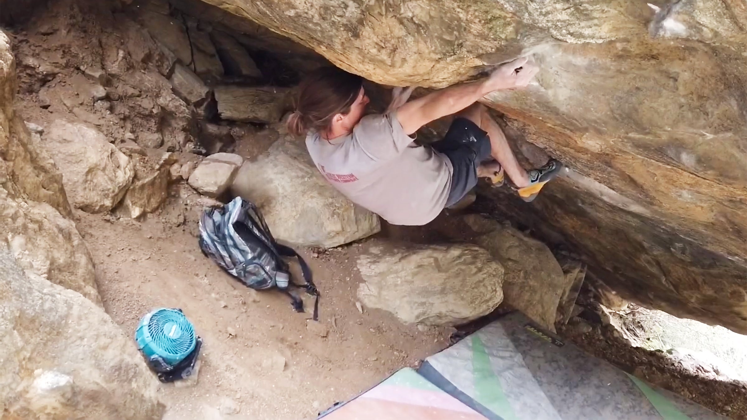 Sam Weir bouldering with a fan