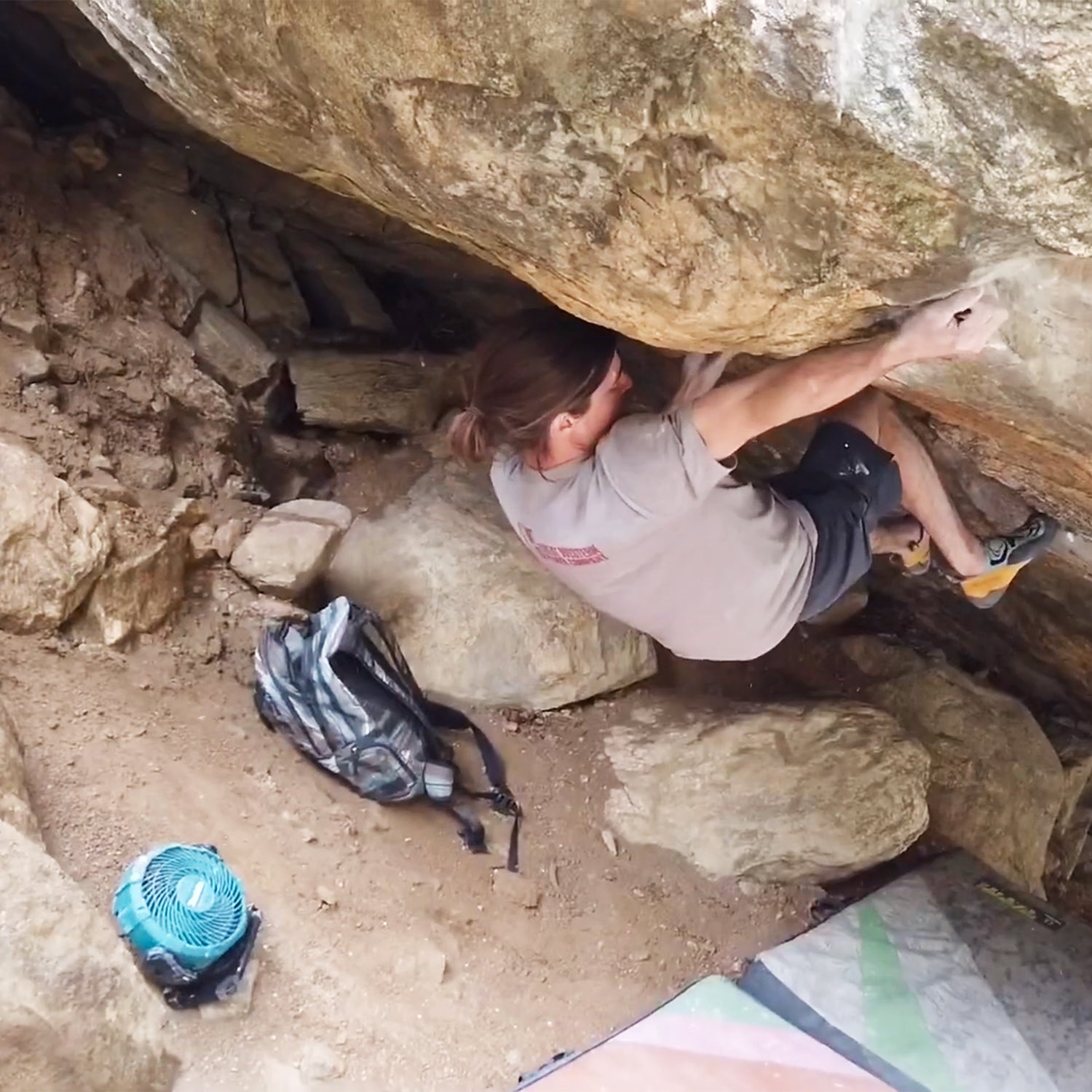 Sam Weir bouldering with a fan