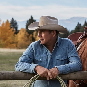 Man and horse leaning against fence