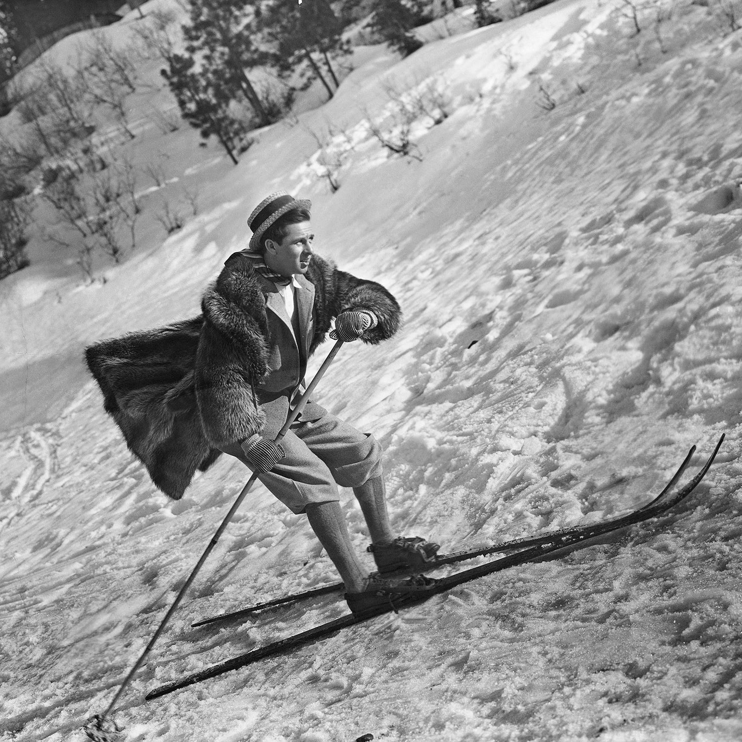 Archival image of actor Ben Lyon skiing in a fur coat