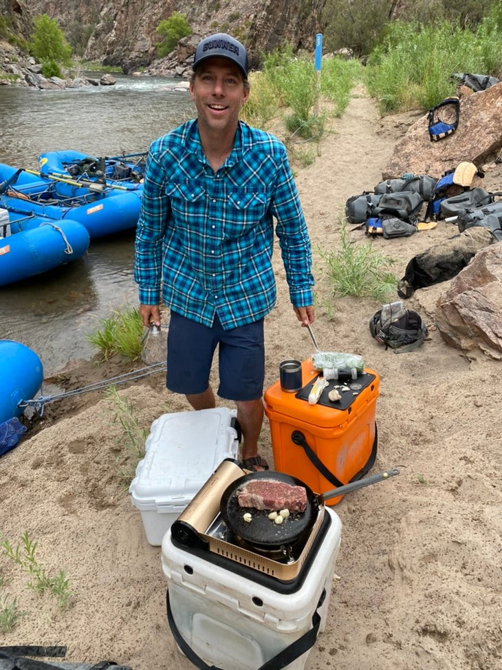 Man with coolers on a riverbank