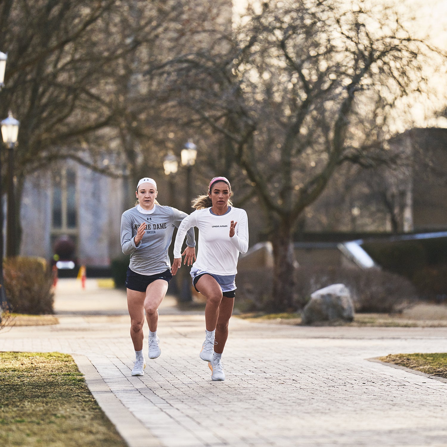 Two women running on a sidewalk.