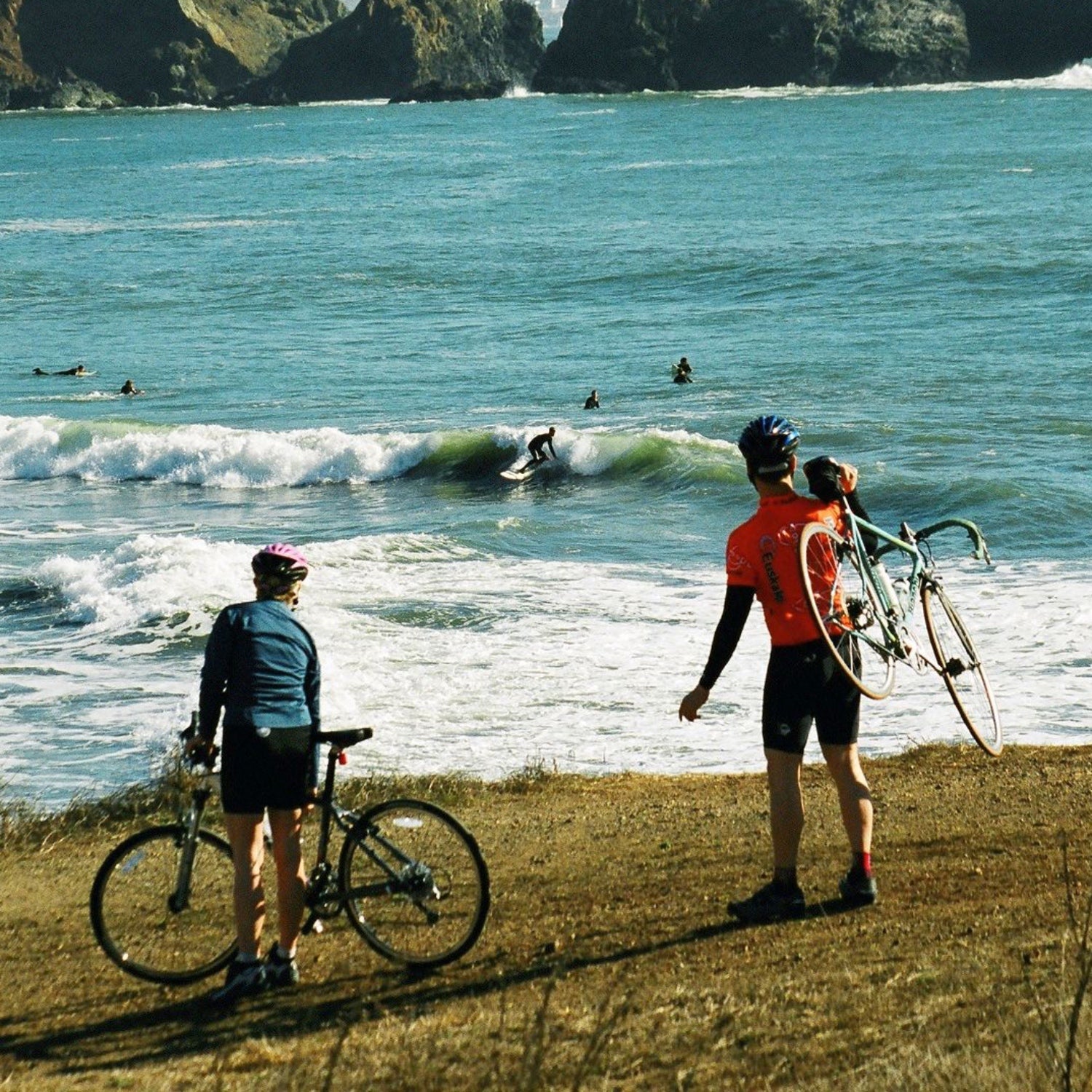 Two mountain bikers watch the surf scene at Rodeo Beach.