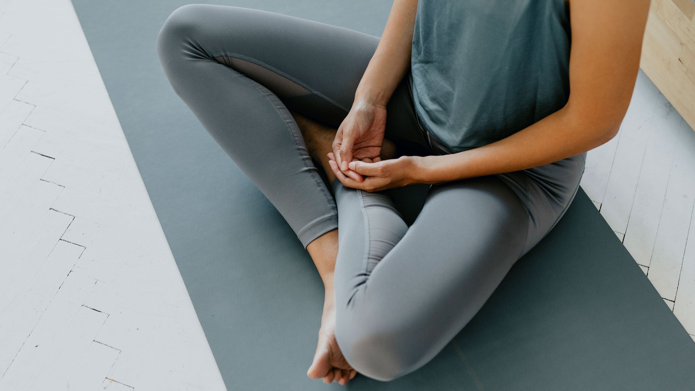Woman practices yoga on her mat