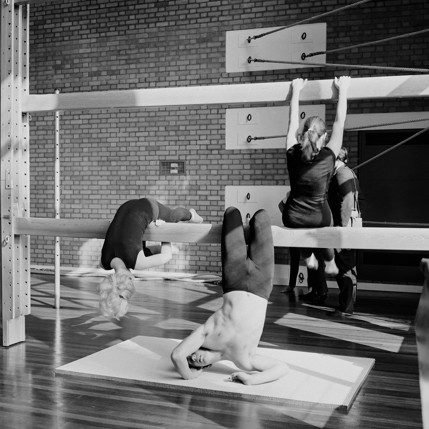 Vintage black and white photo of a gymnastics class using gym equipment