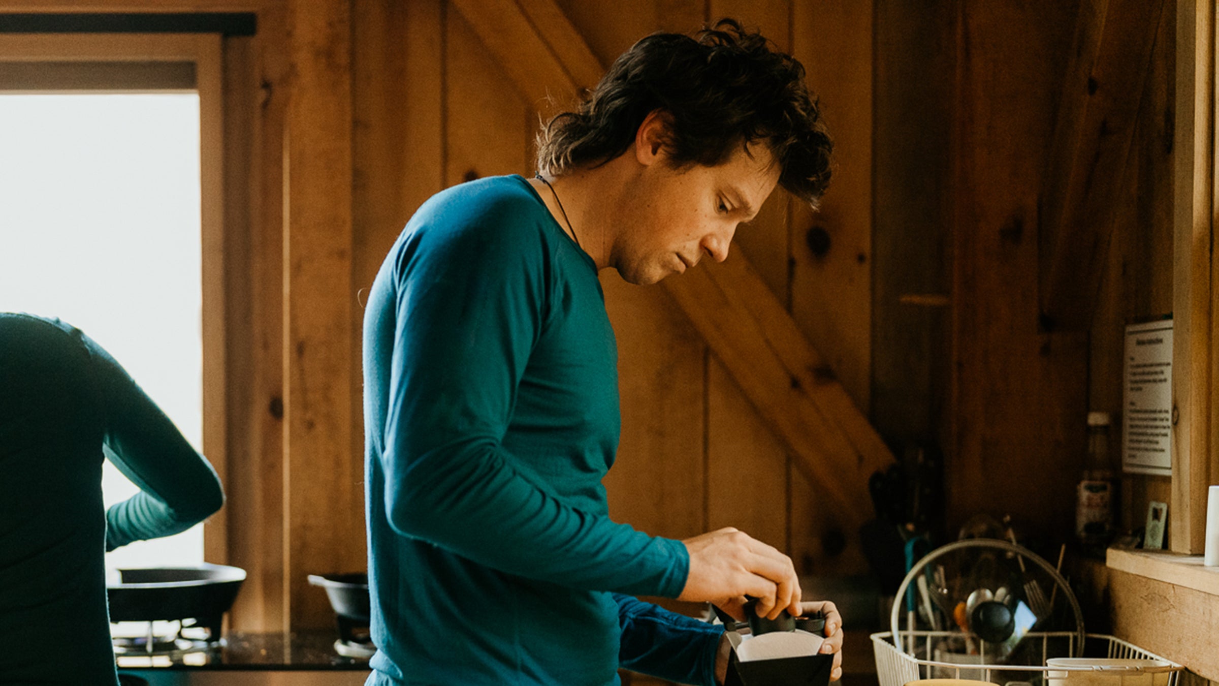 man making coffee wearing merino wool shirt