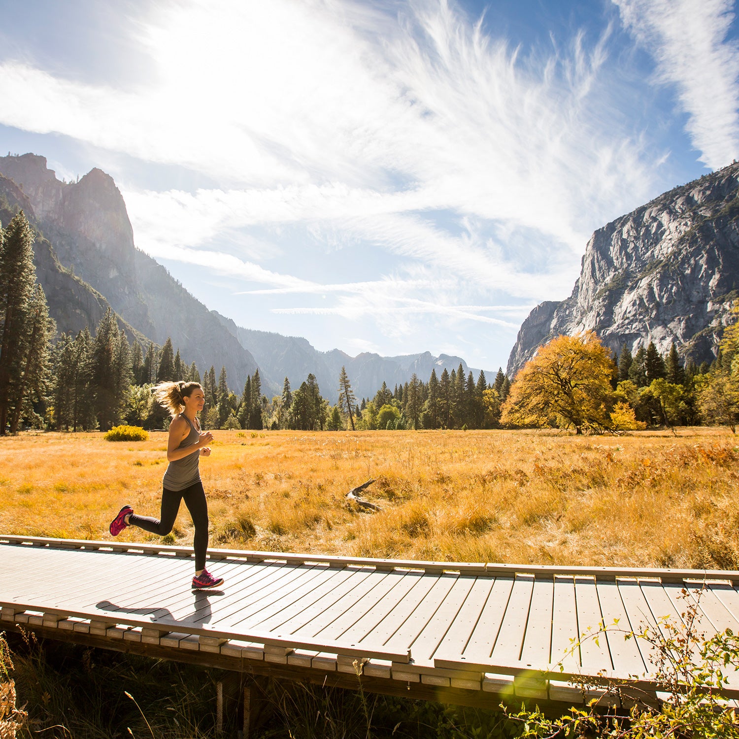 woman running meadow boardwalk