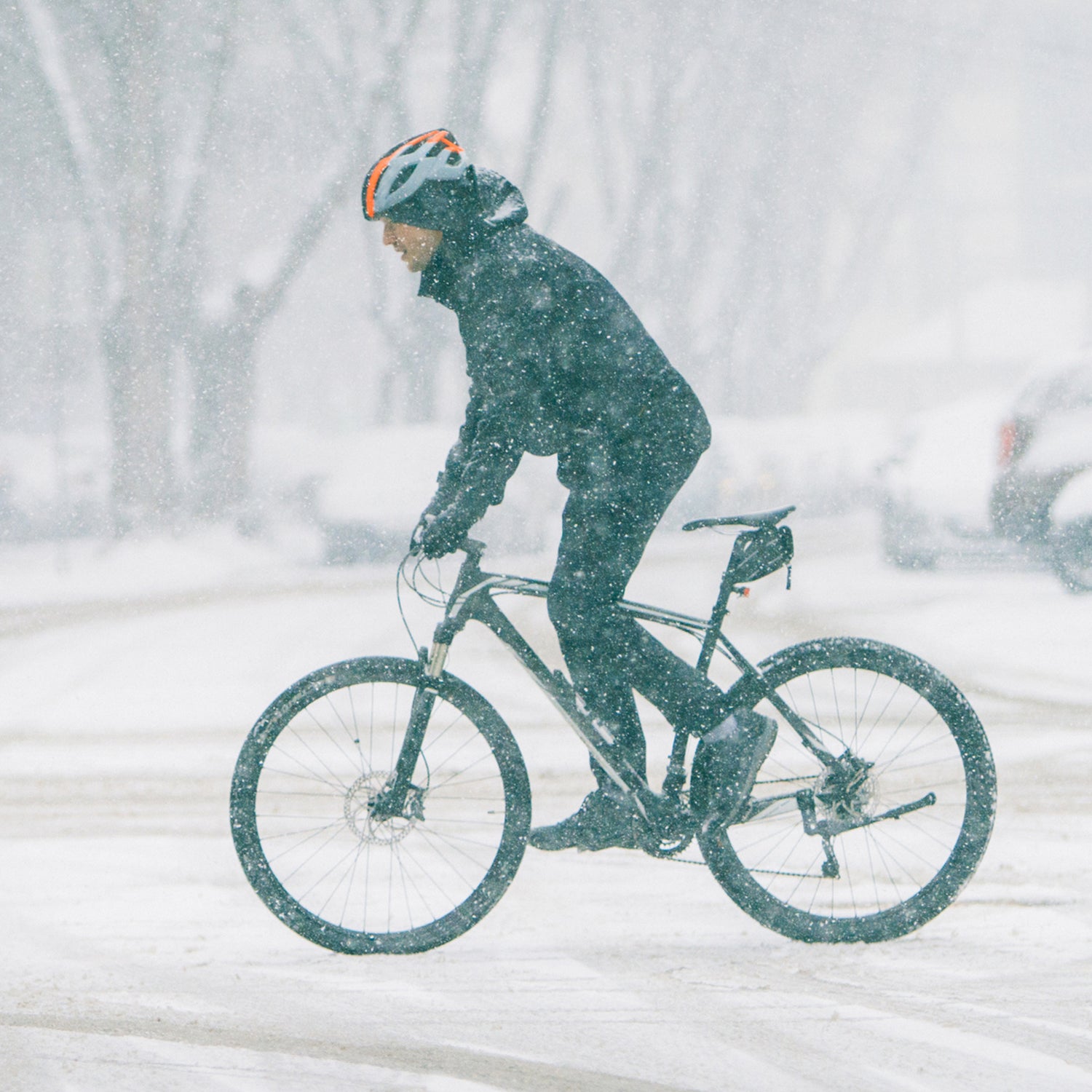 Man riding a bike through the city on the snowy weather