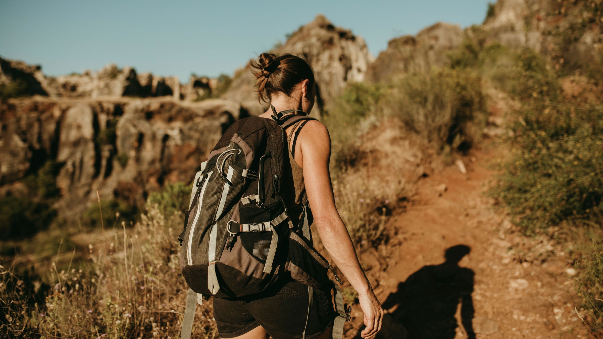 Woman rucking with a pack through the desert