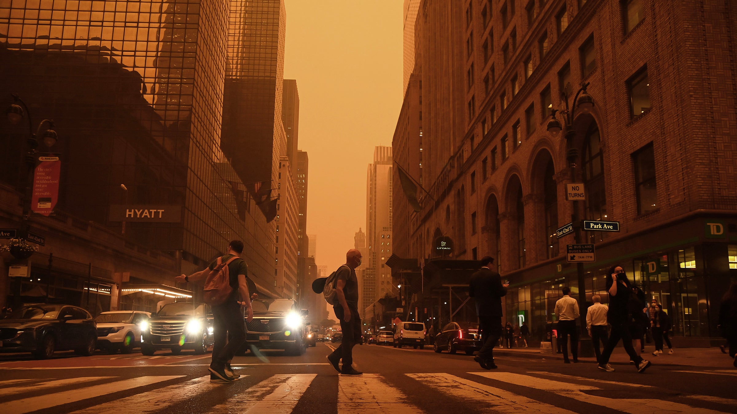 wildfire smoke in a city as people cross the street