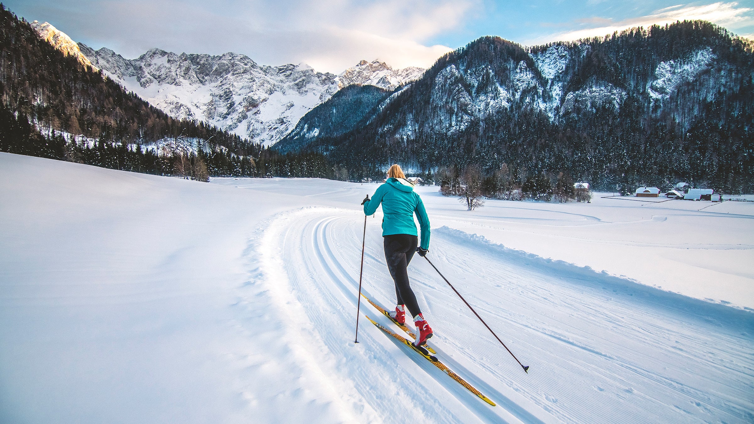 nordic skier in classic tracks with mountain background