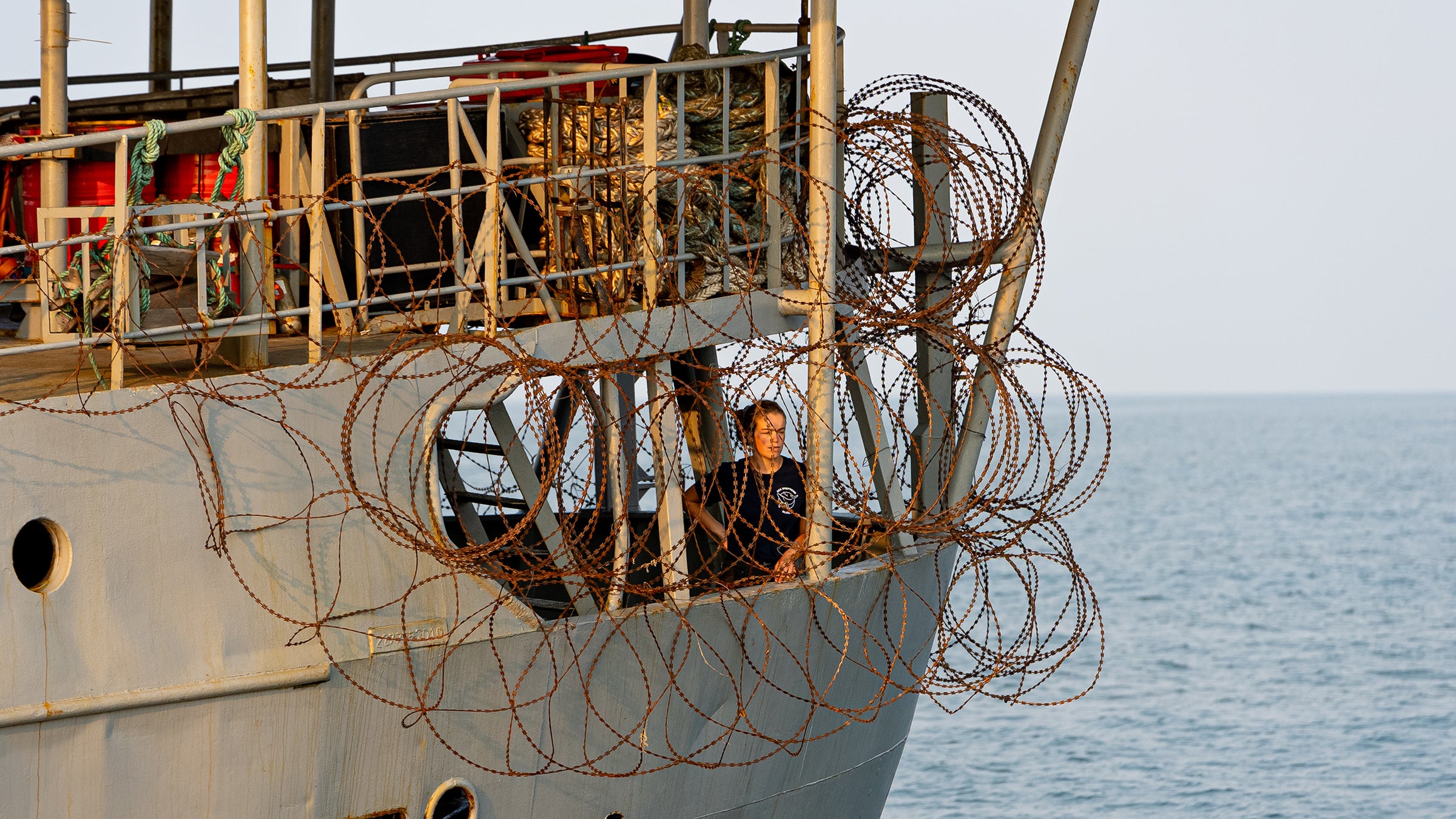 Brigitte looks out from the razor wire covered poop deck on the Bob Barker