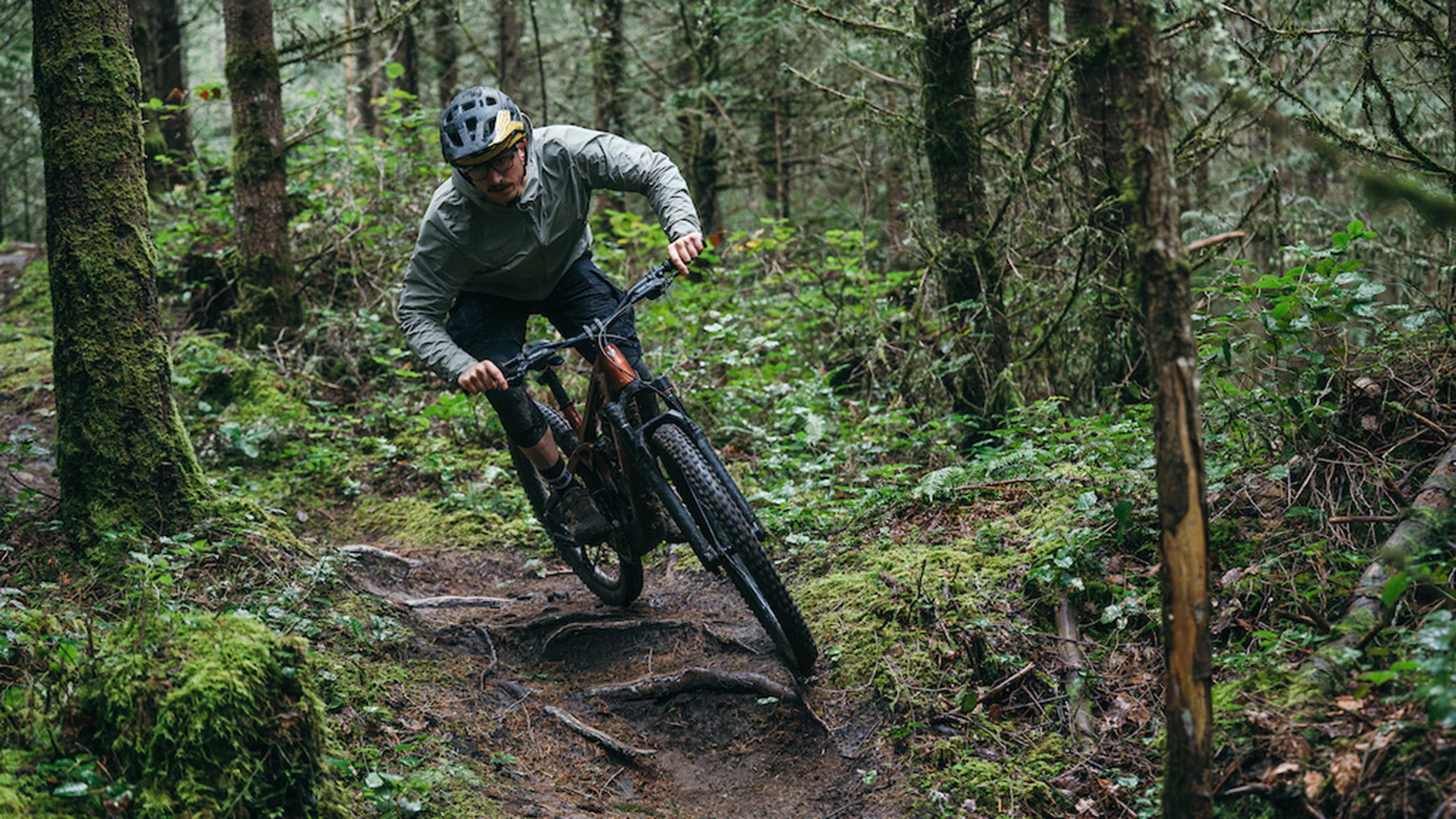 Male mountain biker on Trek Slash+ electric mountain bike on wooded singletrack trail