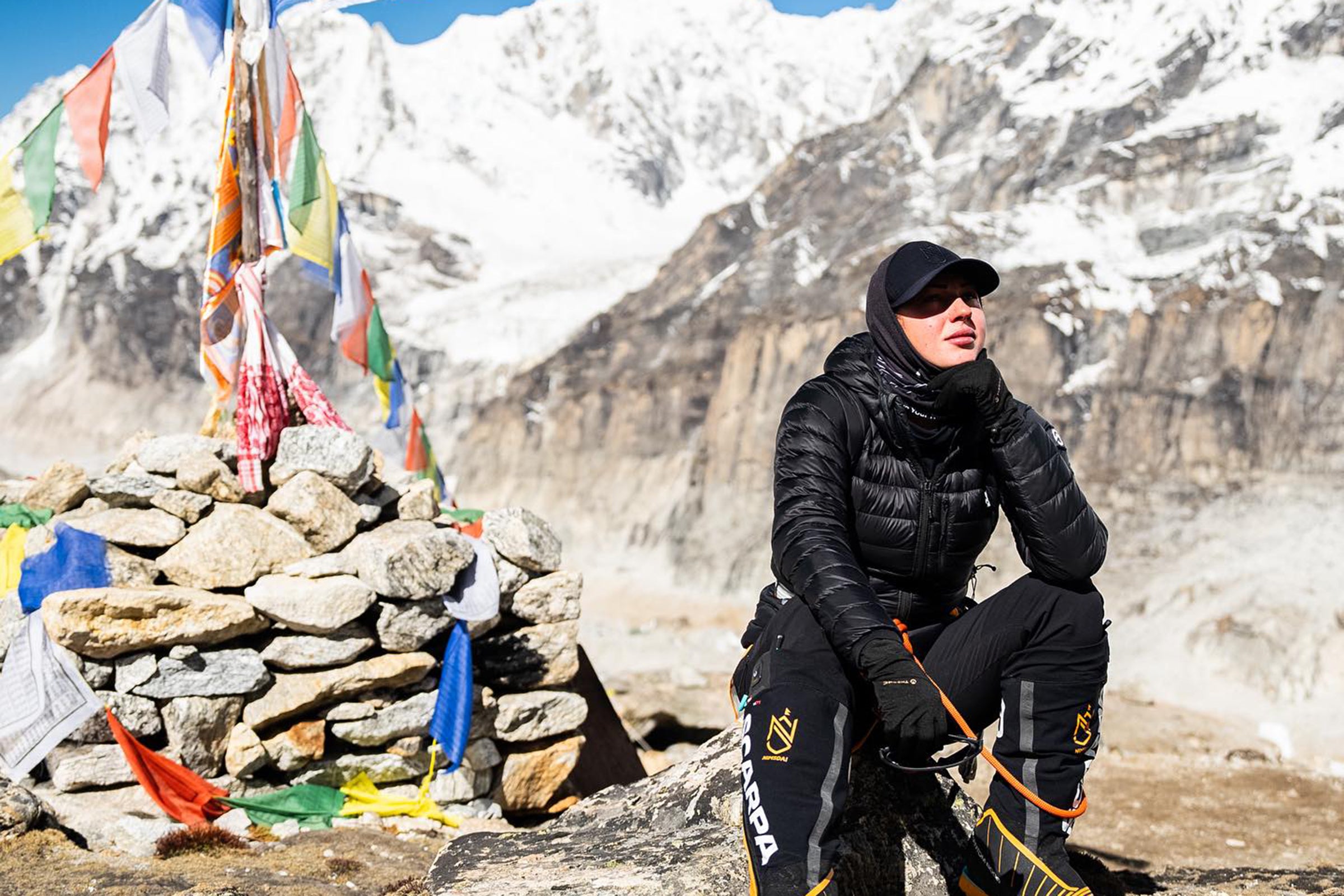 A woman sitting next to a cairn