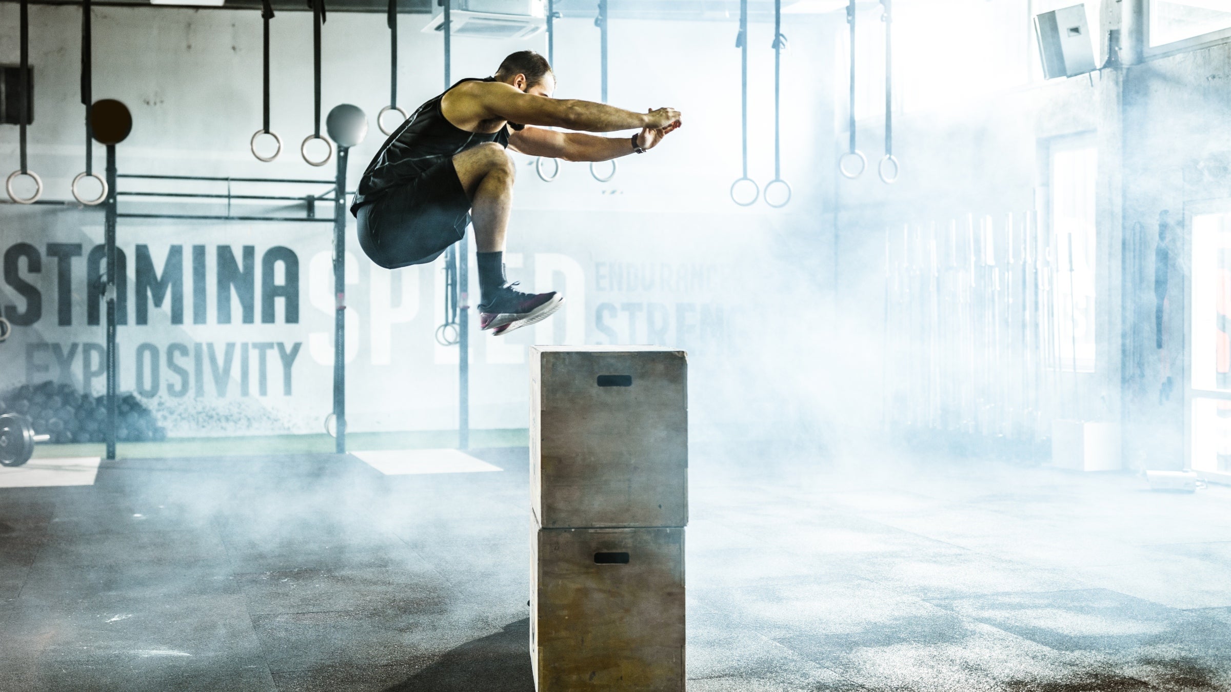 An athlete in midair performing a box jump to increase muscle power