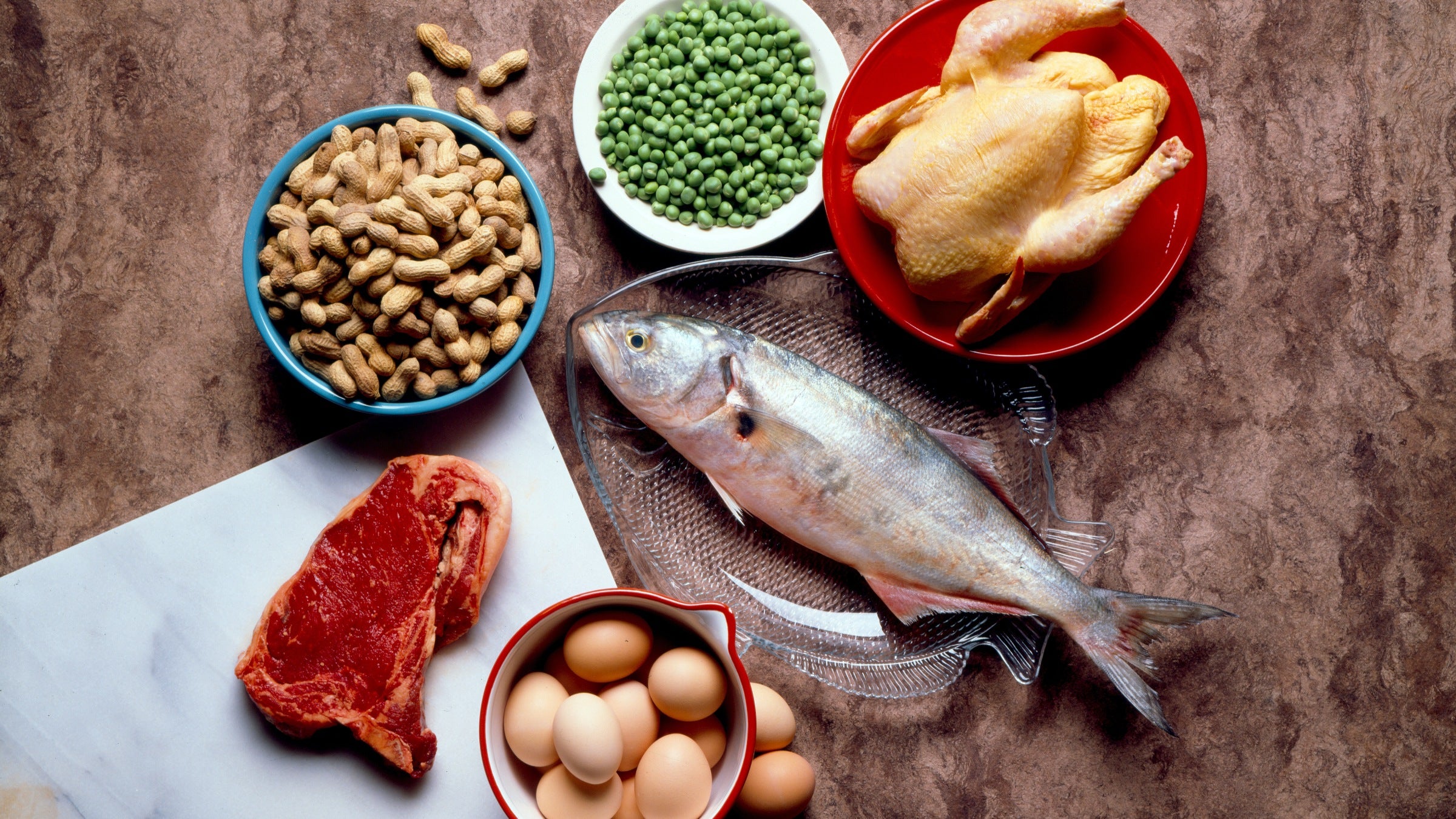 A table featuring many protein sources, including fish, red meat, peas, and eggs.