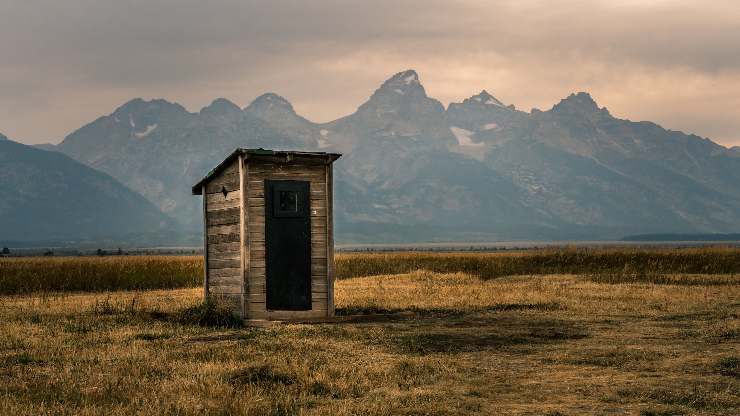 Outhouse in front of the Grand Tetons.