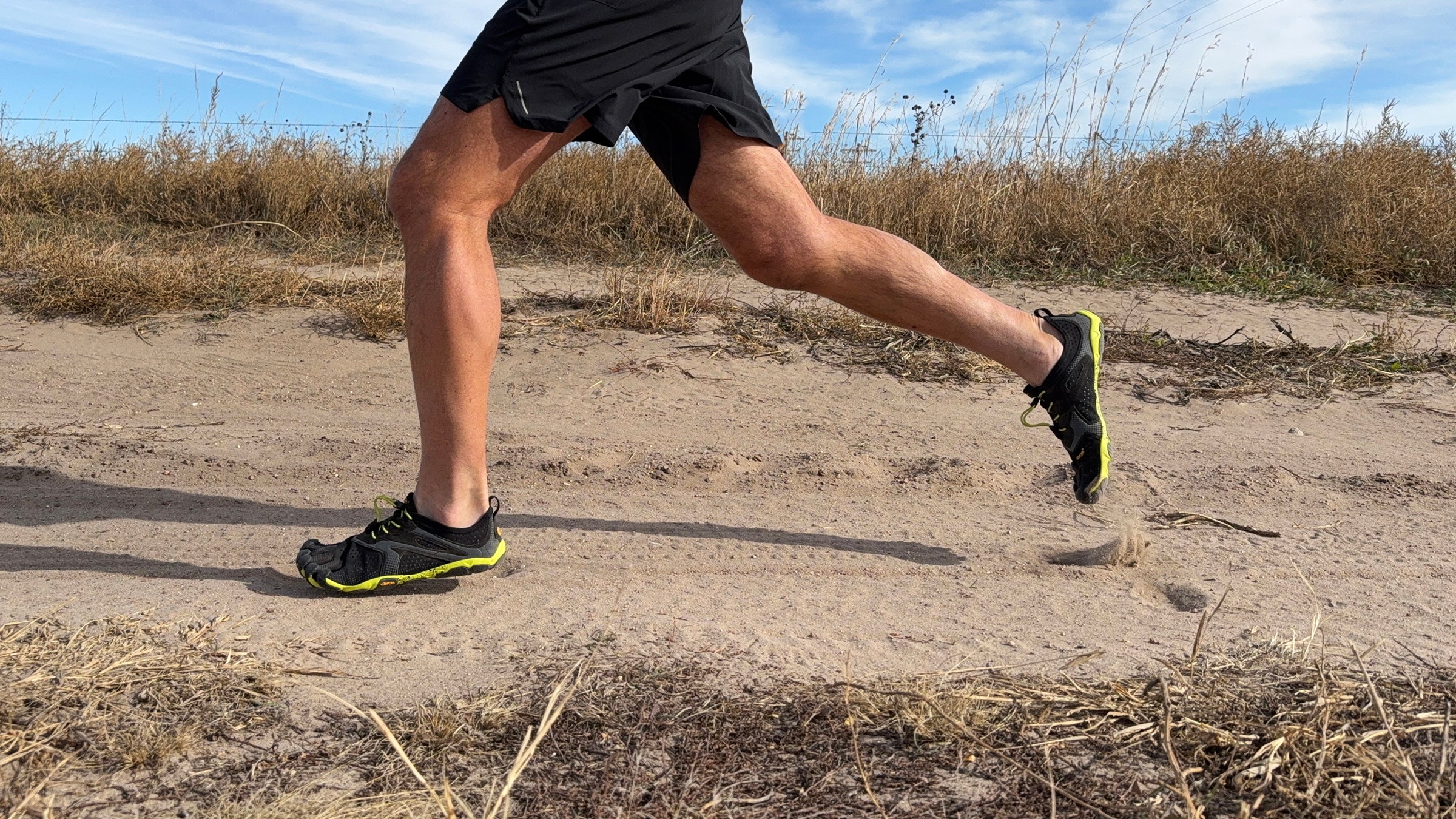 runner's legs in full stride on a trail wearing Vibram FiveFingers