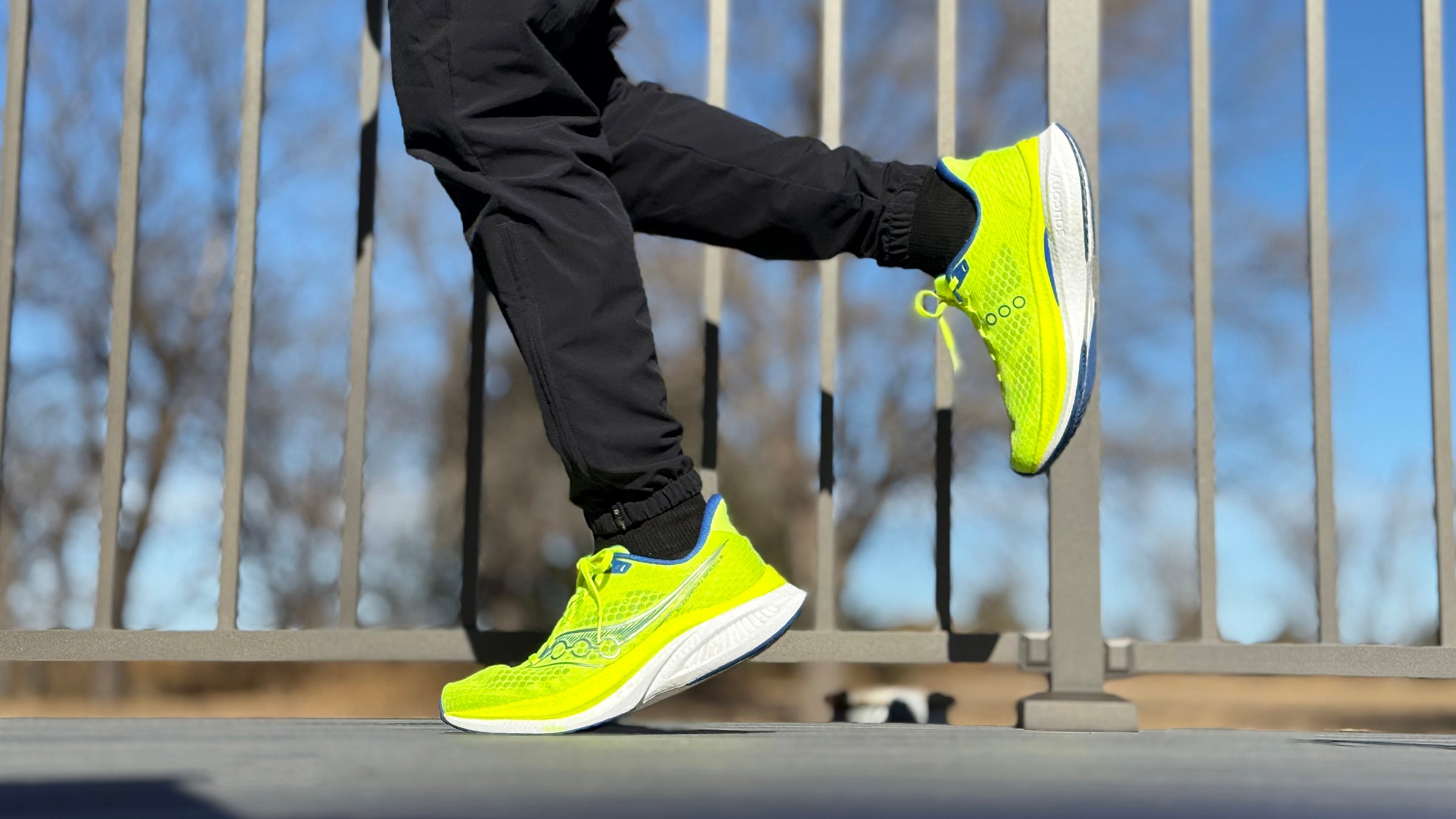 bright yellow running shoes on runner with black tights