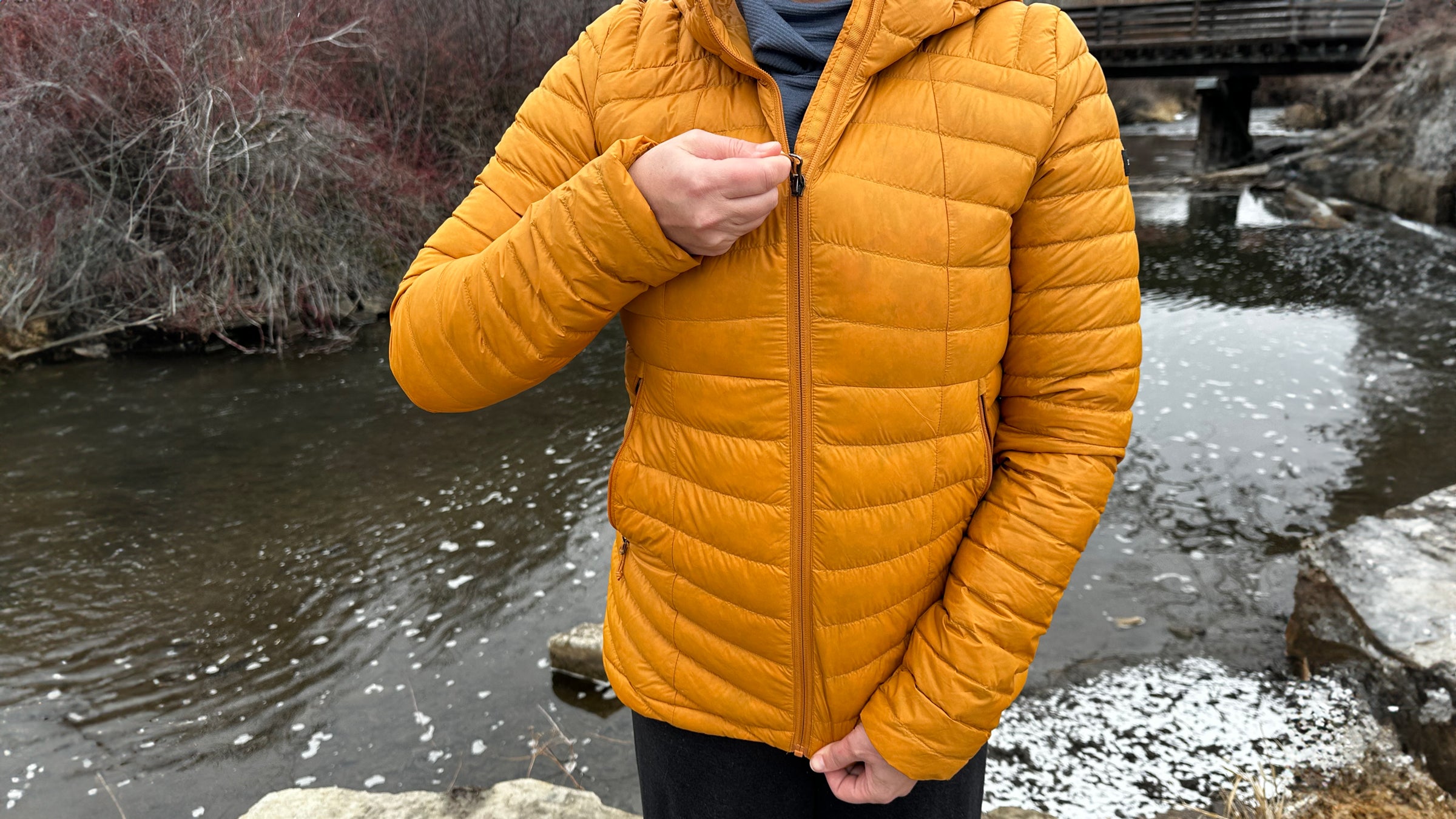 Decathlon Simond MT100 Down Puffer jacket zipping up in front of stream.
