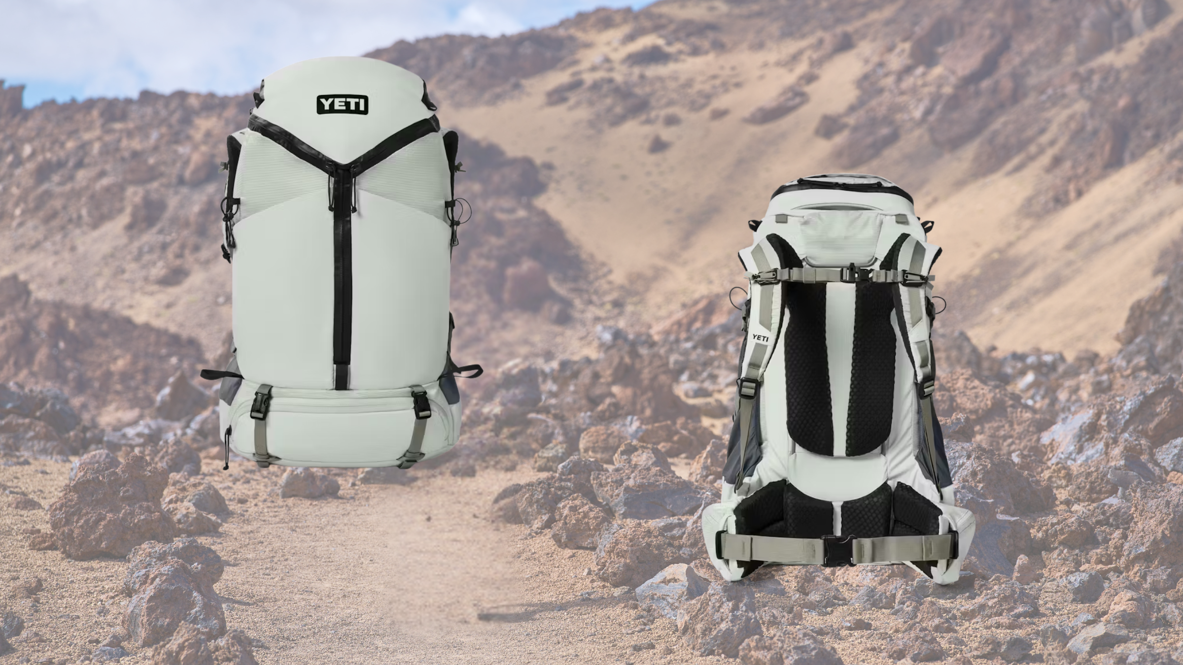 Front and back views of a white YETI Skala 60 hiking backpack shown against a rocky, desert mountain trail background.