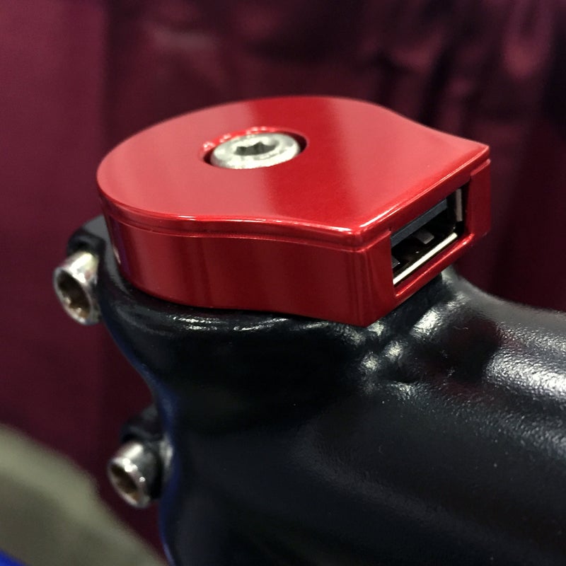 Yes, that's a stem-mounted USB charger. The Sinewave Cycles Reactor works with virtually any dynamo hub and can charge a fully depleted iPhone in about three hours.