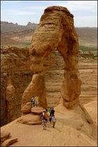 Tourists at the base of 60-foot-tall Delicate Arch.