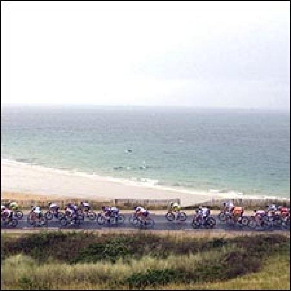 The peloton rode through rainy conditions past the Brittany shore during Saturday's Stage 7.