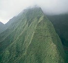 "All the sinister powers of the earth are against you": The great ridge path of kane as it ascends Waialeale's misty peak.