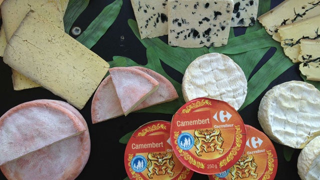 Grilling wheels of Reblochon cheese with Stage 19 playing in the background at Ferme Pepe in Le Grand Bornand.