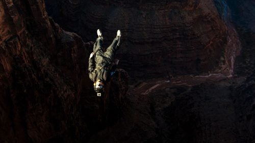 Base jumper Scotty Bob performs an aerial at the beginning of a jump while wearing a tracking suit. This suit inflates with air via several vents and increases the surface area of the jumper, allowing Bob to propel his body forward without the use of a dangerous and restrictive wingsuit.