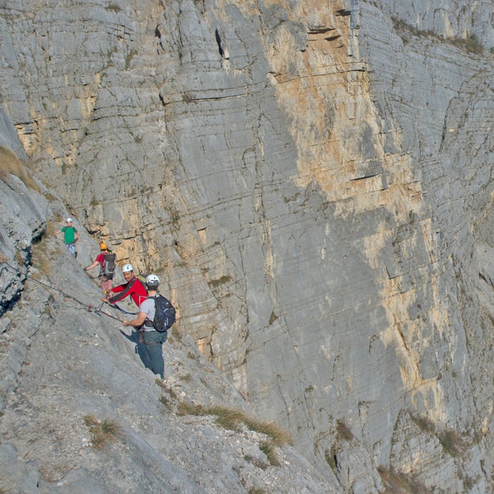 Europeans in the 15th century once scaled the Via Ferrata (Italian for “iron way”) with ladders, and the route was later used during World War I by specialized troops. Today, routes through the Dolomites are much more accessible thanks to new steel cables, ropes, wooden walkways, and suspension bridges. See the problem?
The routes and cables are well maintained, but your safety hinges on snapping a specialized carabiner setup (called a via ferrata set) to the anchors on the cable supports.
Then, you'll scale sheer faces and edge around tall ledges. Deaths have happened on routes of all difficulty levels under a variety of circumstances. In 2009, one British woman plunged to her death on an intermediate hike after slipping on snow and falling 600 feet. Another death in Austria happened because of a gear failure. Watch pro mountain biker Harald Philipp tackle the route on a mountain bike.