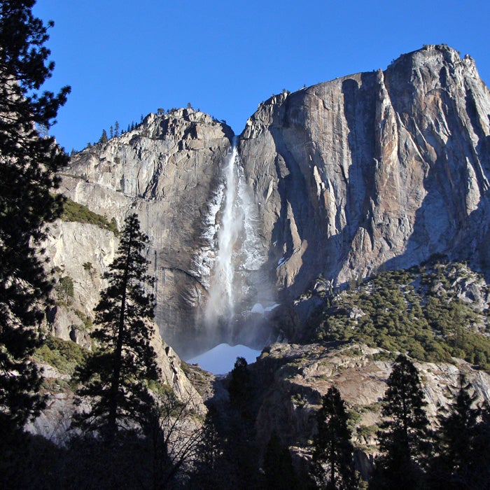 Best For: Experiencing Vertigo
Aside from Half Dome, the Yosemite Falls Trail is one of the park’s most popular strenuous trails. It’s also one of the oldest. As snow begins to melt, North America’s tallest waterfall is an amazing spectacle.
On cold spring days, mist ices the granite wall around the falls, creating a white halo. As the sun warms the rock, the giant sheets of ice crash to the ground. The sound is alarming, and the giant, white snow cone at the base of the falls will conjure visions of ice-cream mountains. But this wintry show only lasts until April, at the latest.
The trail climbs more than 2,700 vertical feet from the valley floor. Dozens of lookouts dot the trail, so it’s not necessary to summit to get a grand view. From Oh My Gosh Rock, about halfway up, you can lean over dizzying heights to spot the upper, middle, and lower sections of the cascade. Columbia Rock is a great stop for lunch, as well as a fair place to turn around in early spring, since snow can become an issue above this area.