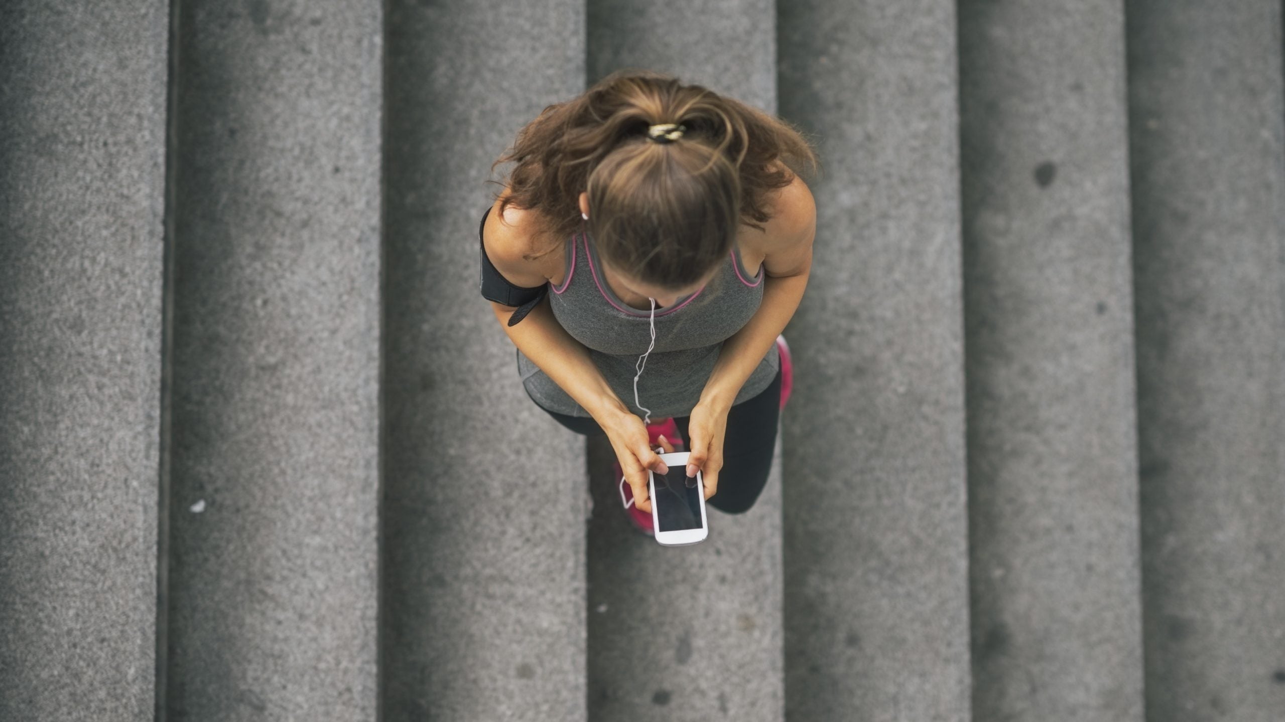 fitness fit sport exercise train athlete trainer training woman female outdoors urban city young mobile phone cell cellphone cellular music mp3 earphones headphones Directly Above copy space sportswear workout health healthcare wellness healthy slim thin wellbeing caucasian white