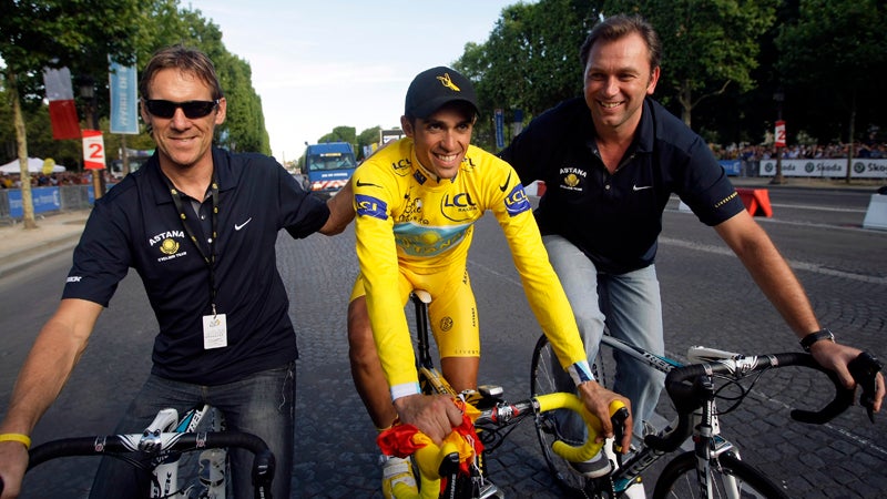 Tour de France winner Alberto Contador of Spain, wearing the overall leader's yellow jersey, center, rides with Astana sports directors Johan Bruyneel of Belgium, right, and Dirk Demol of Belgium, after winning his second Tour de France cycling race, on the Champs Elysees avenue after the 21st stage of the Tour de France cycling race over 164 kilometers (101.9 miles) with start in Montereau-Fault-Yonne and finish in Paris, France, Sunday July 26, 2009. (AP Photo/Bas Czerwinski)