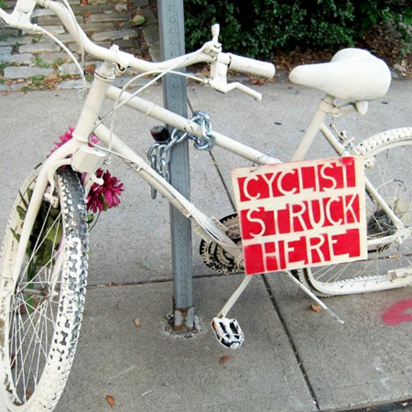 A ghost bike in Pittsburgh, Pennsylvania. Ghost bikes, painted white and placed at scenes of cycling accidents, serve as memorials for cyclists hit or killed on the street.