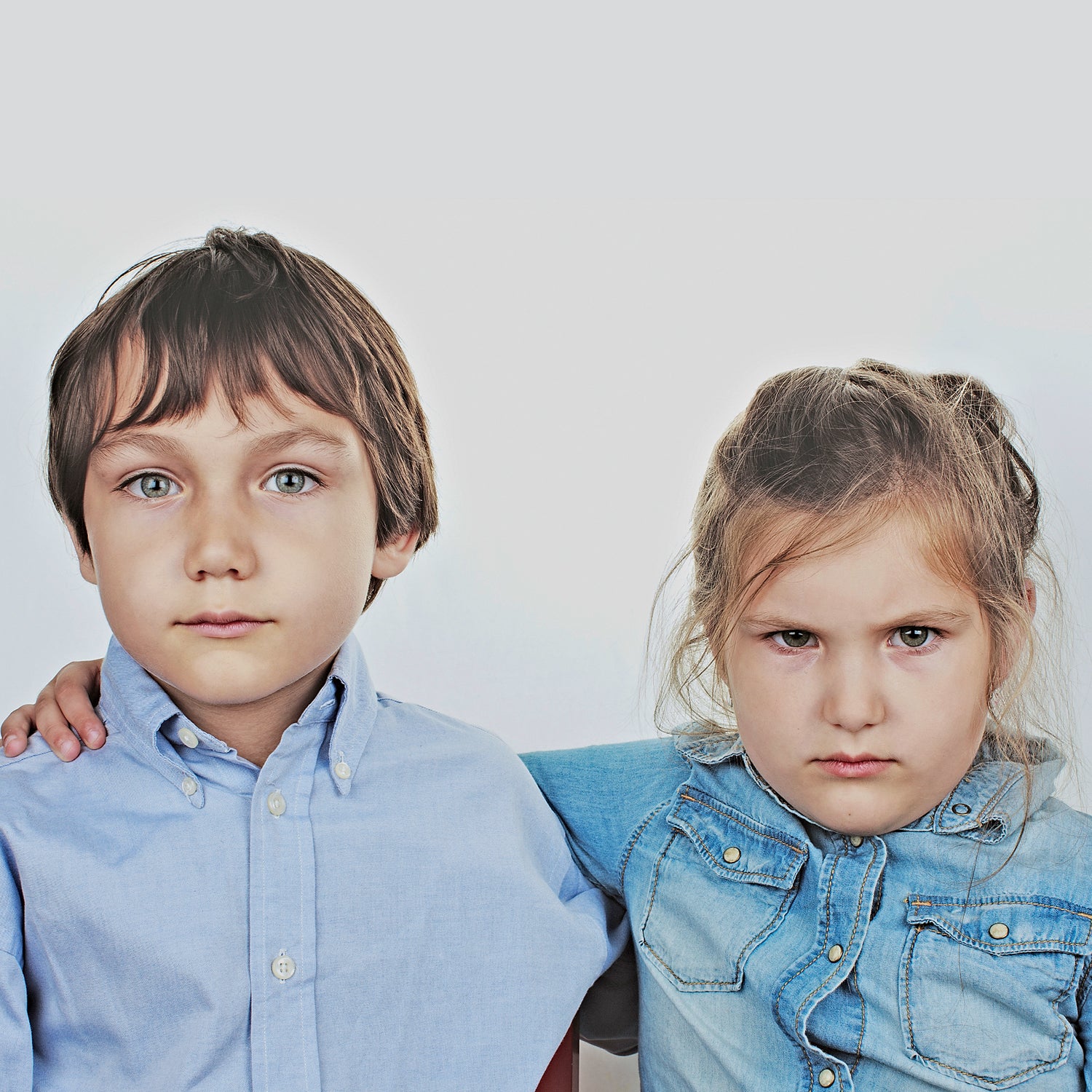 4-5 Years Anger Bonding Boy Brunette Hair Casual Clothing Caucasian Ethnicity Childhood Children Only Friendship Front View Girl Hugging Indoors Innocence Leisure Lifestyles Looking At Camera Portrait Serious Sibling Simplicity Studio Shot Togetherness Two People Waist Up White Background
