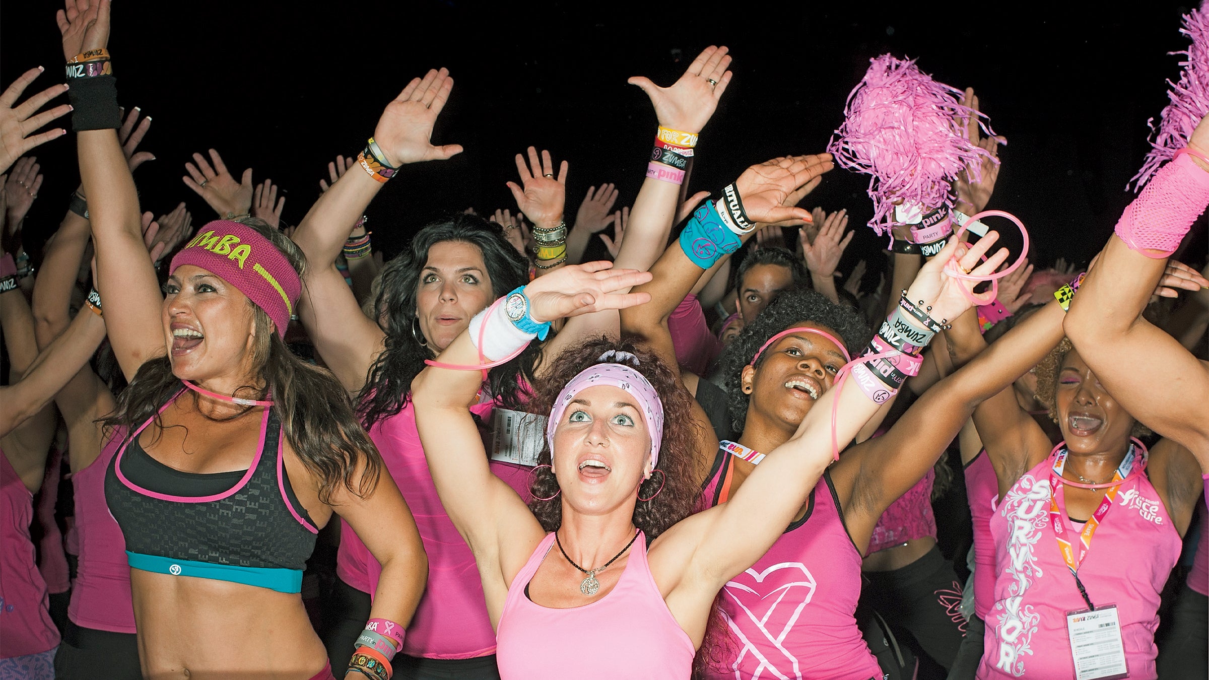 20-29 Years Anticipation Carefree Caucasian Ethnicity Cheerful Convention Center Dancing Enjoyment Exhilaration Femininity Fitness Front View Gesturing Hand Raised Happiness Indoors Leisure Lifestyles Medium Group Of People Pink Pom Pom Portrait Railing Smiling Spectator Standing Tank Top Text Three Quarter Length Togetherness Vitality Waving Weekend Activities Western Script Woman Young Woman Youth Culture Zumba