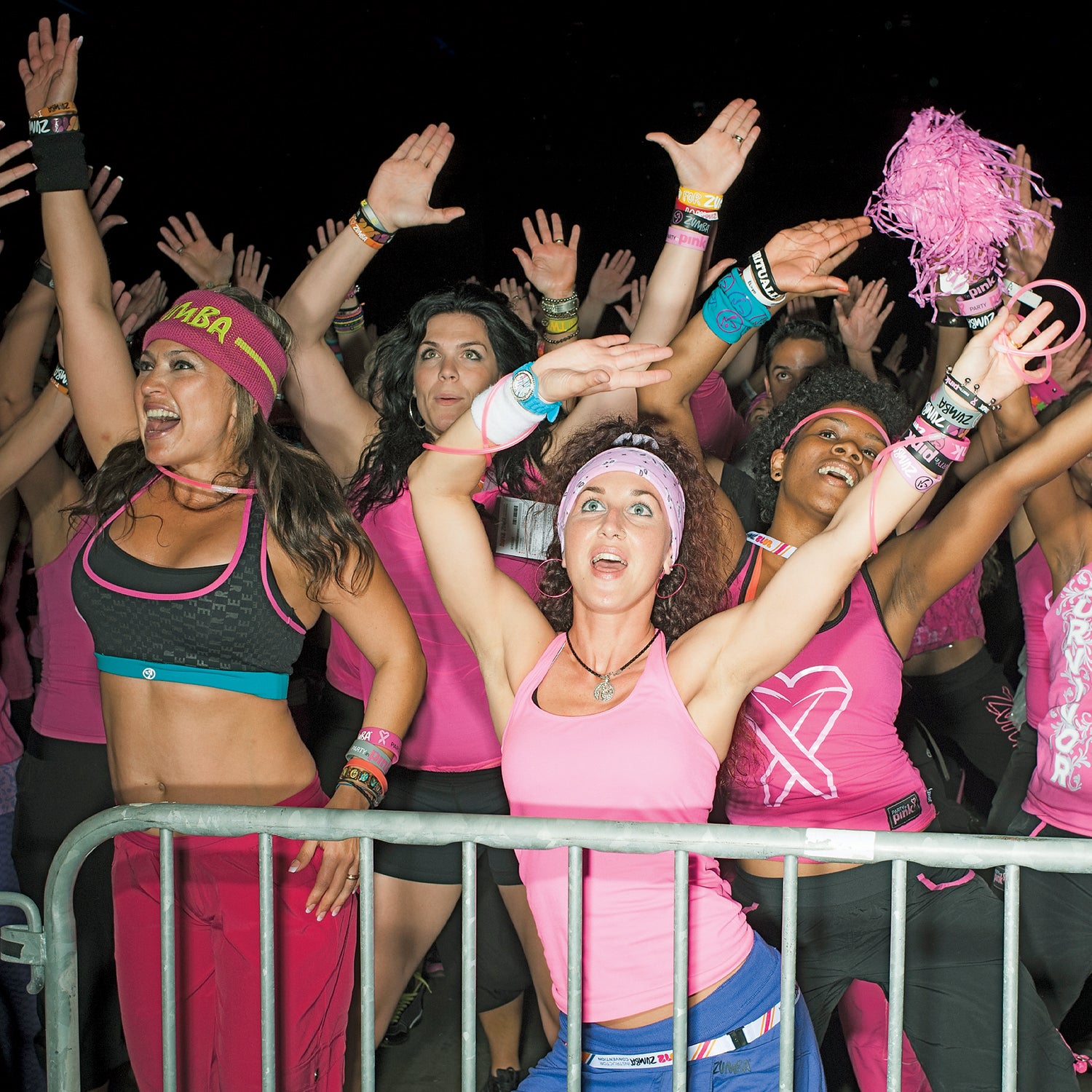20-29 Years Anticipation Carefree Caucasian Ethnicity Cheerful Convention Center Dancing Enjoyment Exhilaration Femininity Fitness Front View Gesturing Hand Raised Happiness Indoors Leisure Lifestyles Medium Group Of People Pink Pom Pom Portrait Railing Smiling Spectator Standing Tank Top Text Three Quarter Length Togetherness Vitality Waving Weekend Activities Western Script Woman Young Woman Youth Culture Zumba